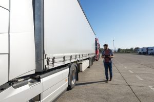 truck driver inspecting vehicle trailer and tires before driving 300x200 1 - Sindicamp